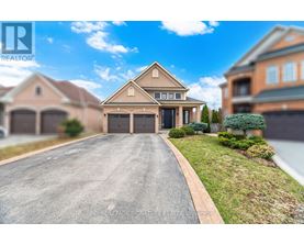 A large, well-maintained house with a driveway in front.