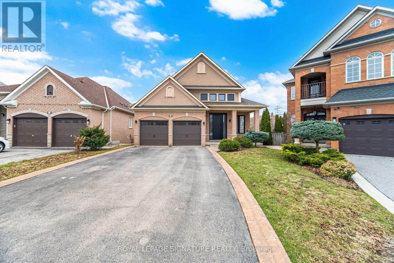 A large, well-maintained house with a driveway in front.