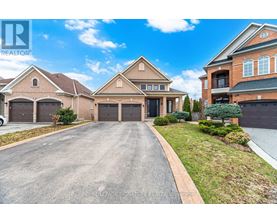 A large, well-maintained house with a driveway in front.