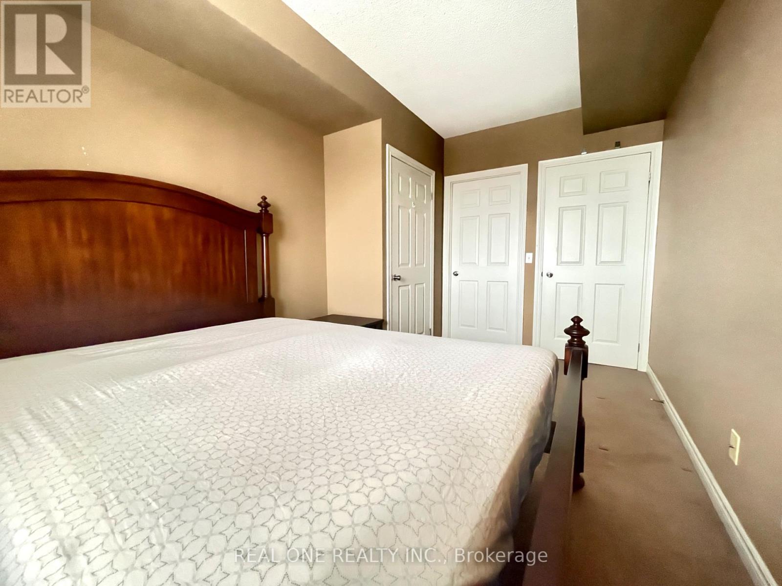A bedroom with a large bed and two doors.