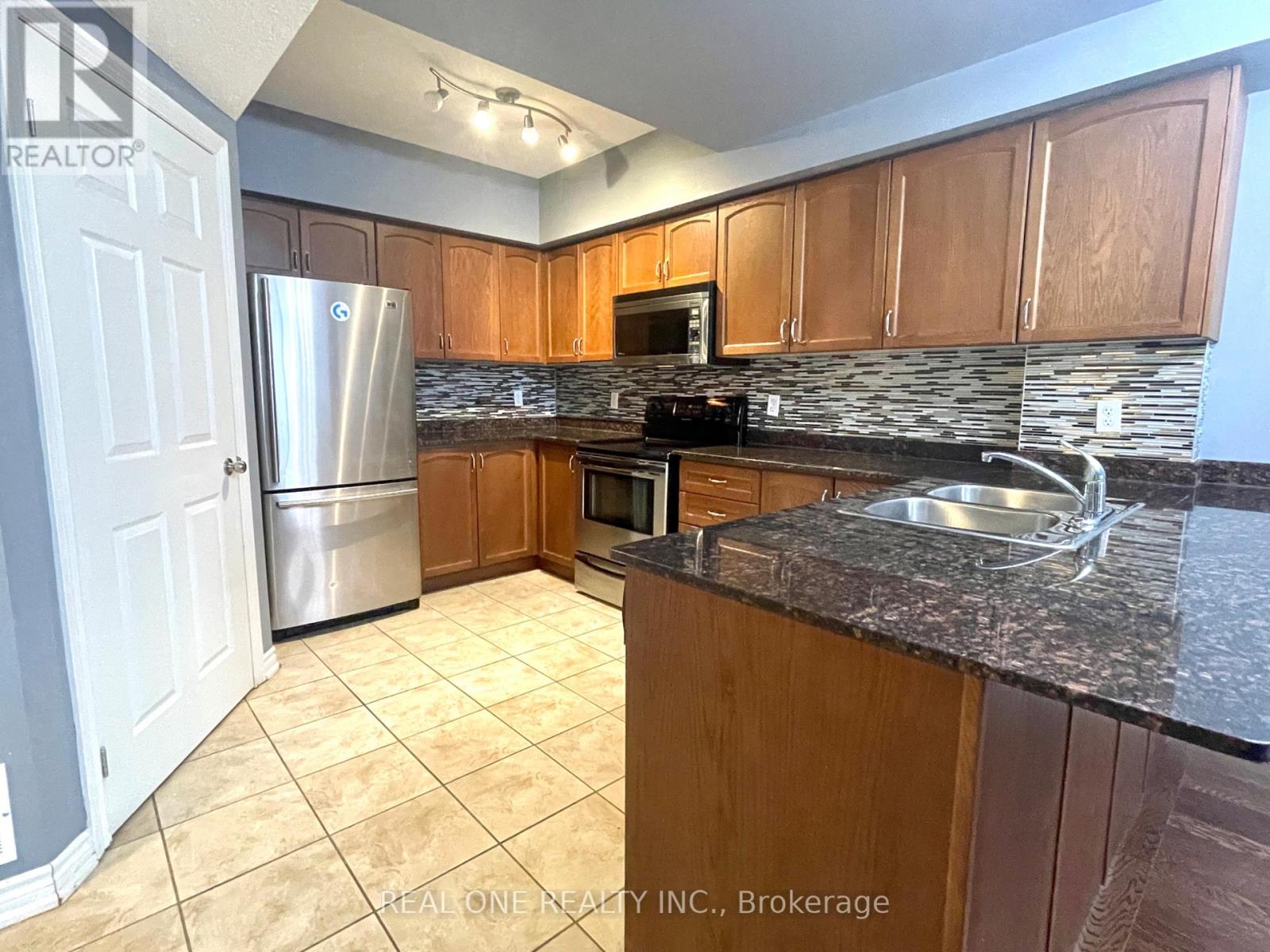 A kitchen with wooden cabinets and granite countertops.