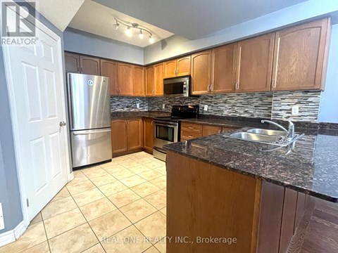 A kitchen with wooden cabinets and granite countertops.