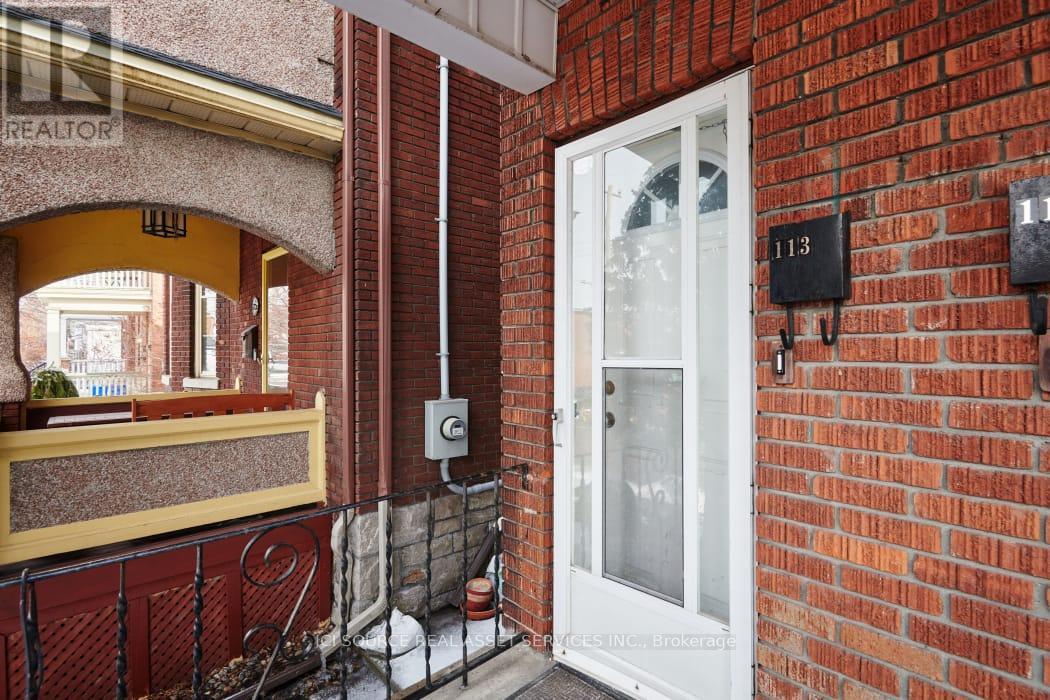 A red brick building with a white door and a sign that says "REALTOR".