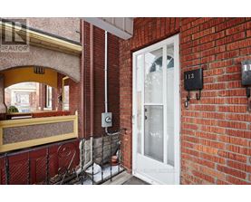 A red brick building with a white door and a sign that says "REALTOR".