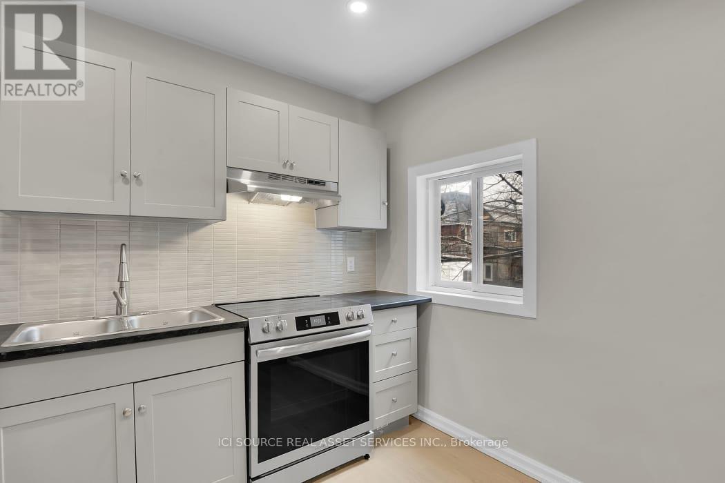 A kitchen with white cabinets and a black stove top oven.