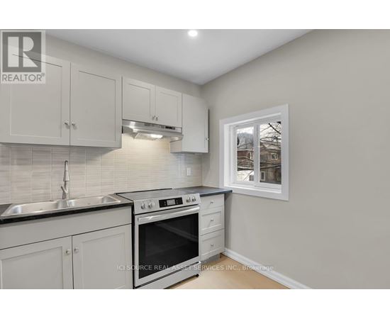 A kitchen with white cabinets and a black stove top oven.