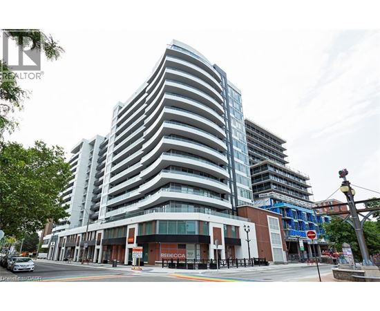 A tall, modern building with a curved design is the focal point of the image.