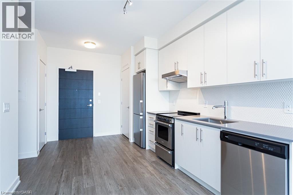 A kitchen with white cabinets and a black fridge.