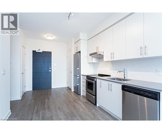 A kitchen with white cabinets and a black fridge.