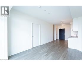 A spacious room with wooden flooring and white walls.
