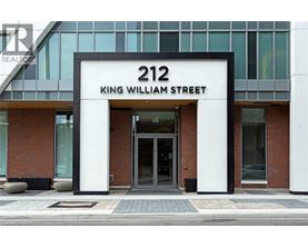 The front of a building with a glass facade and a sign that reads "212 King William Street.".