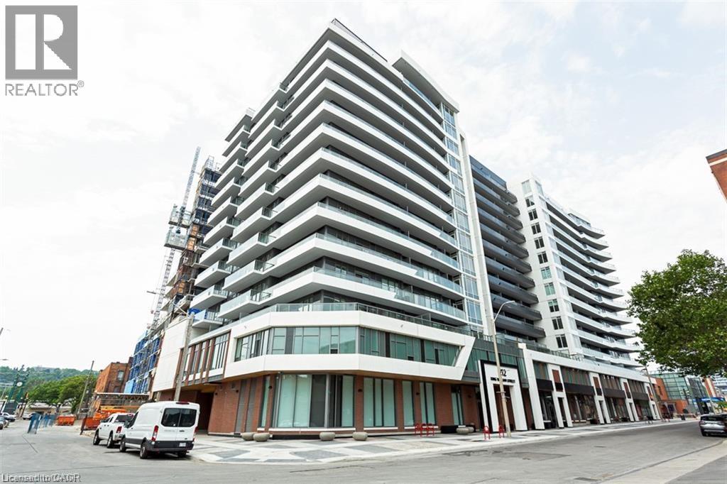 A modern multi-story building with a glass facade is under construction.