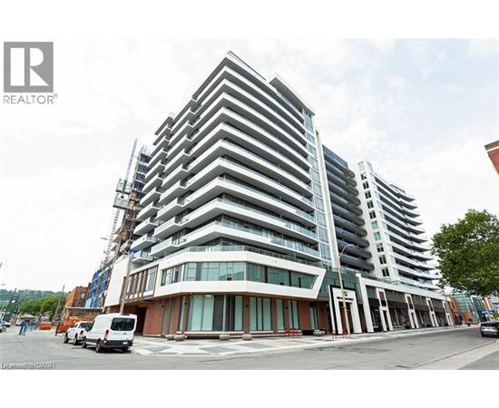 A modern multi-story building with a glass facade is under construction.