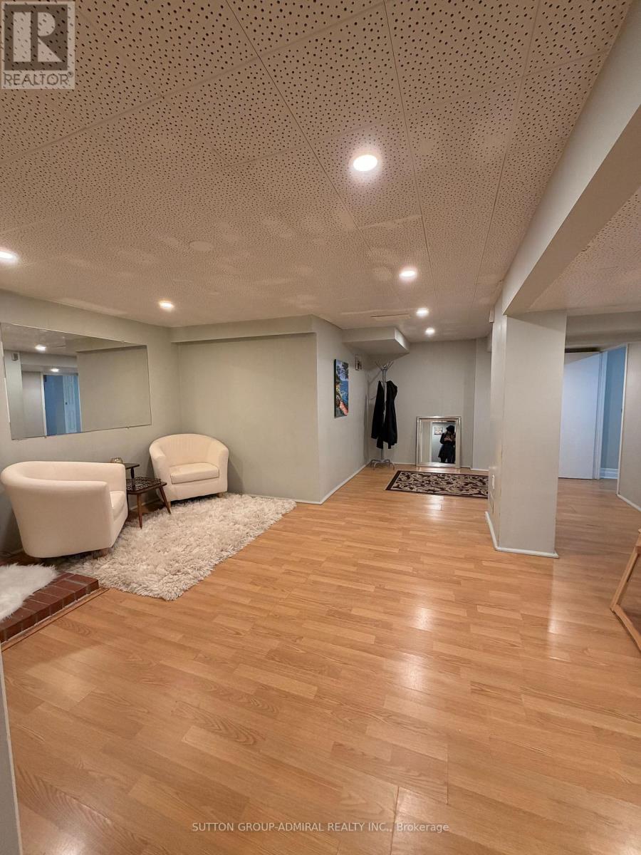 A spacious room with wooden flooring and a white chair.