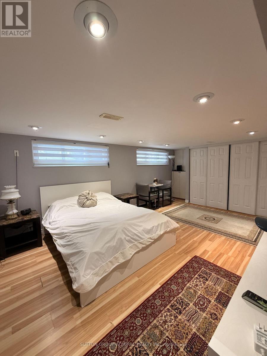 A bedroom with a large bed and a rug on the floor.