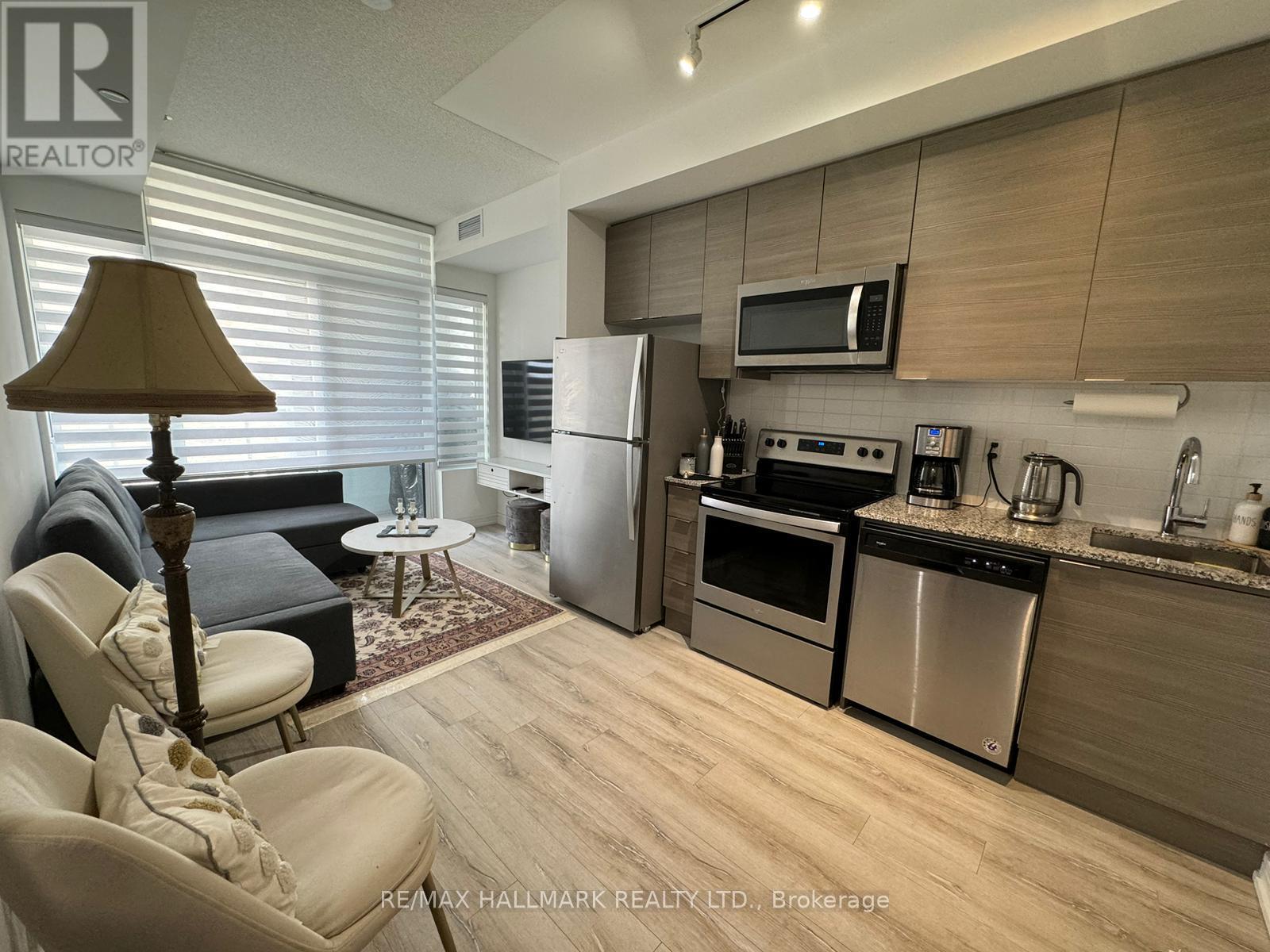 A modern kitchen with a refrigerator, oven, and microwave.