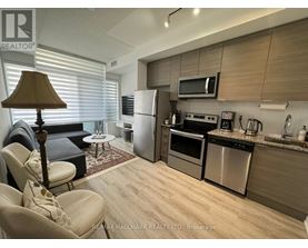 A modern kitchen with a refrigerator, oven, and microwave.
