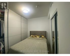 A bedroom with a bed and a wall-mounted light fixture.