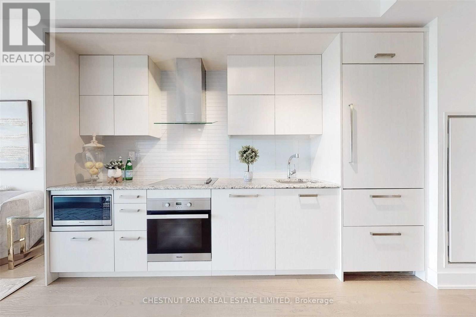 A modern kitchen with white cabinets and appliances.
