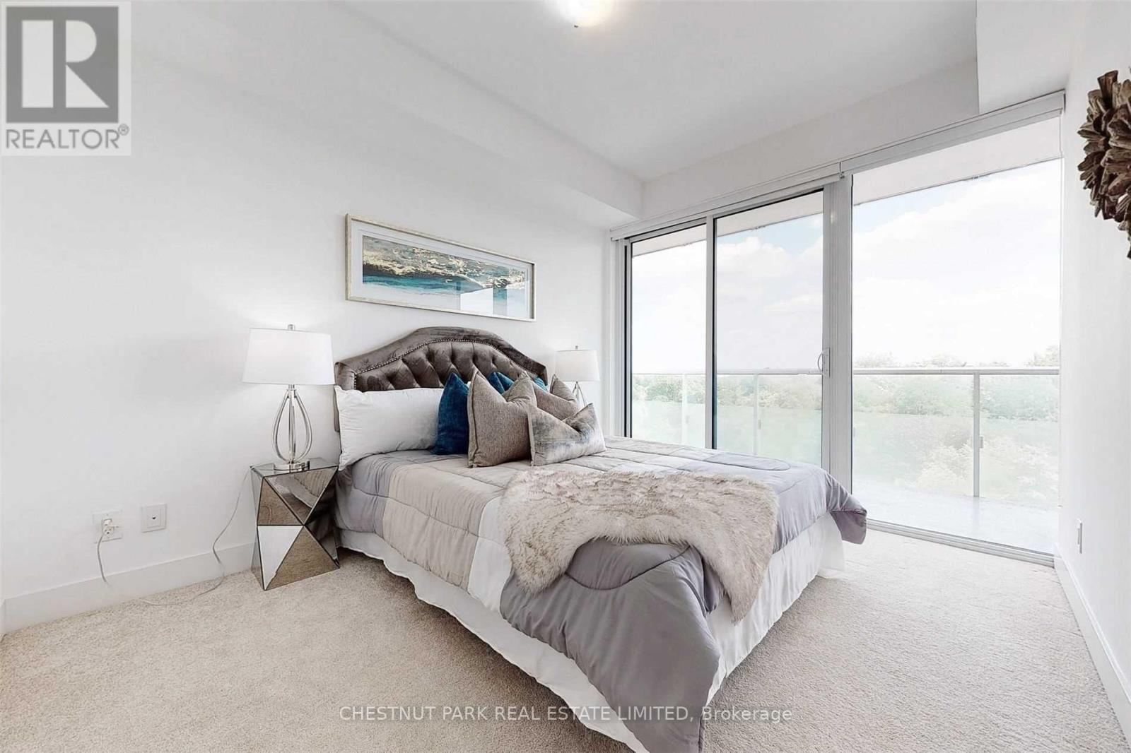 A bedroom with a large bed and a painting on the wall.