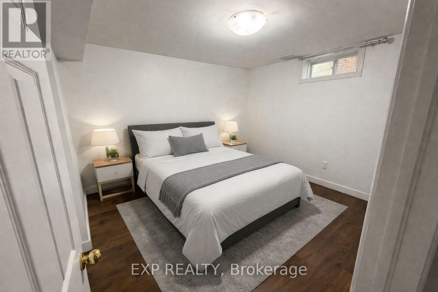 A bedroom with a bed, nightstands, and a rug.