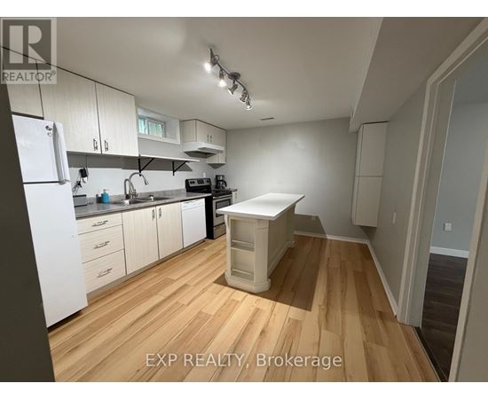 A kitchen with white cabinets and a wooden floor.