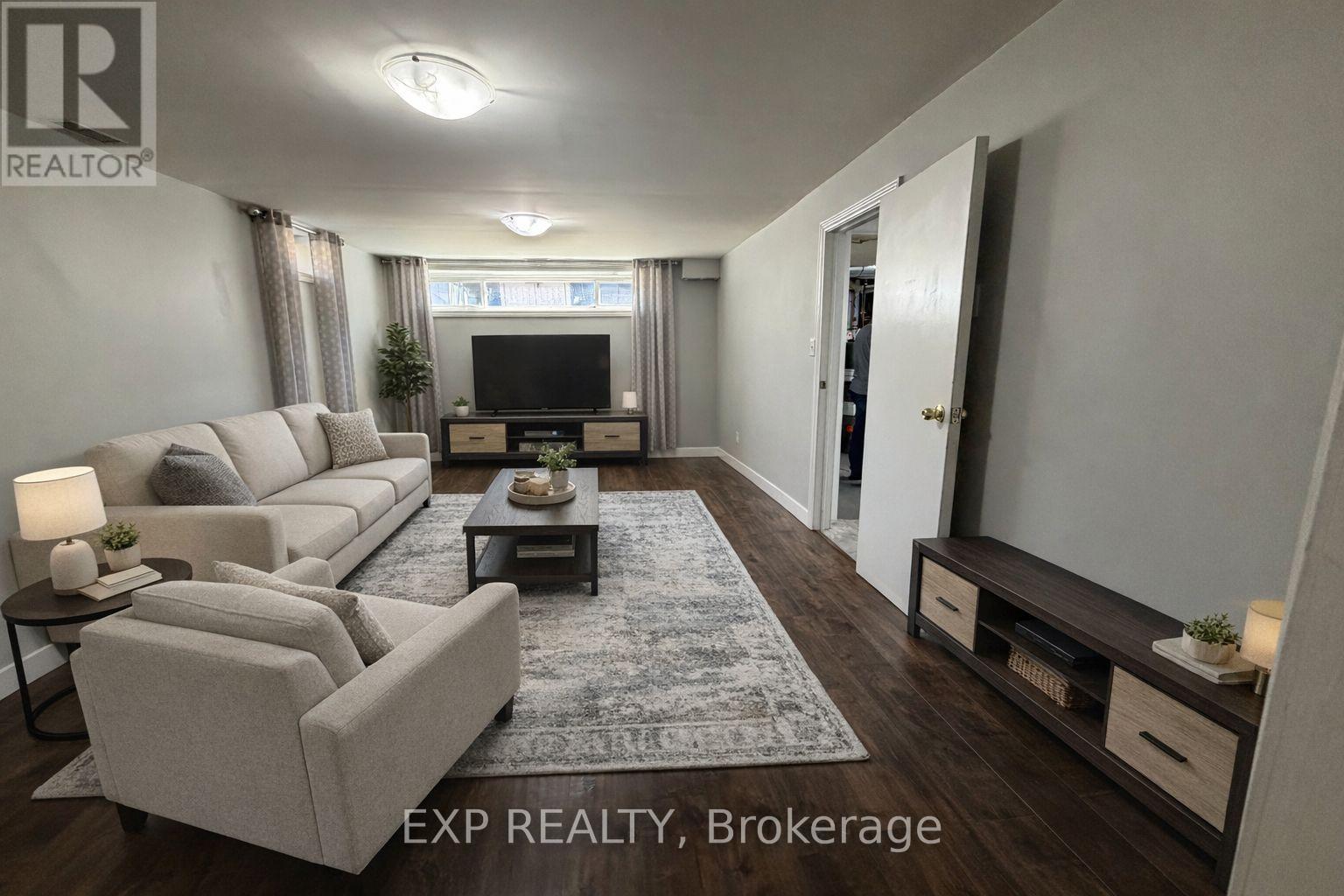 A living room with a grey sofa, a coffee table, and a television.