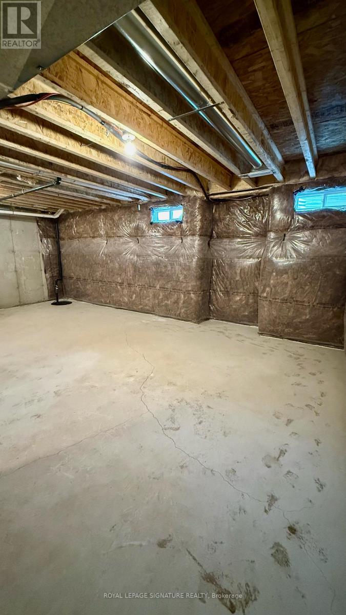 A sparsely furnished attic with insulation and wooden beams.
