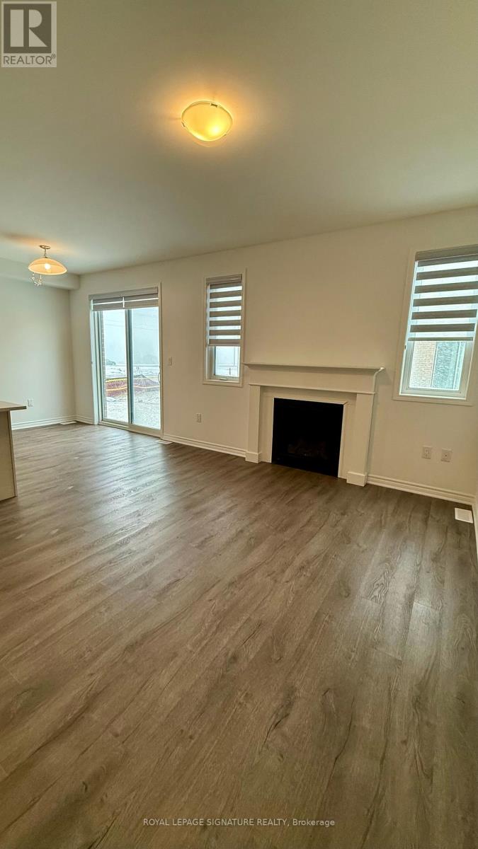 A living room with a fireplace and wood flooring.
