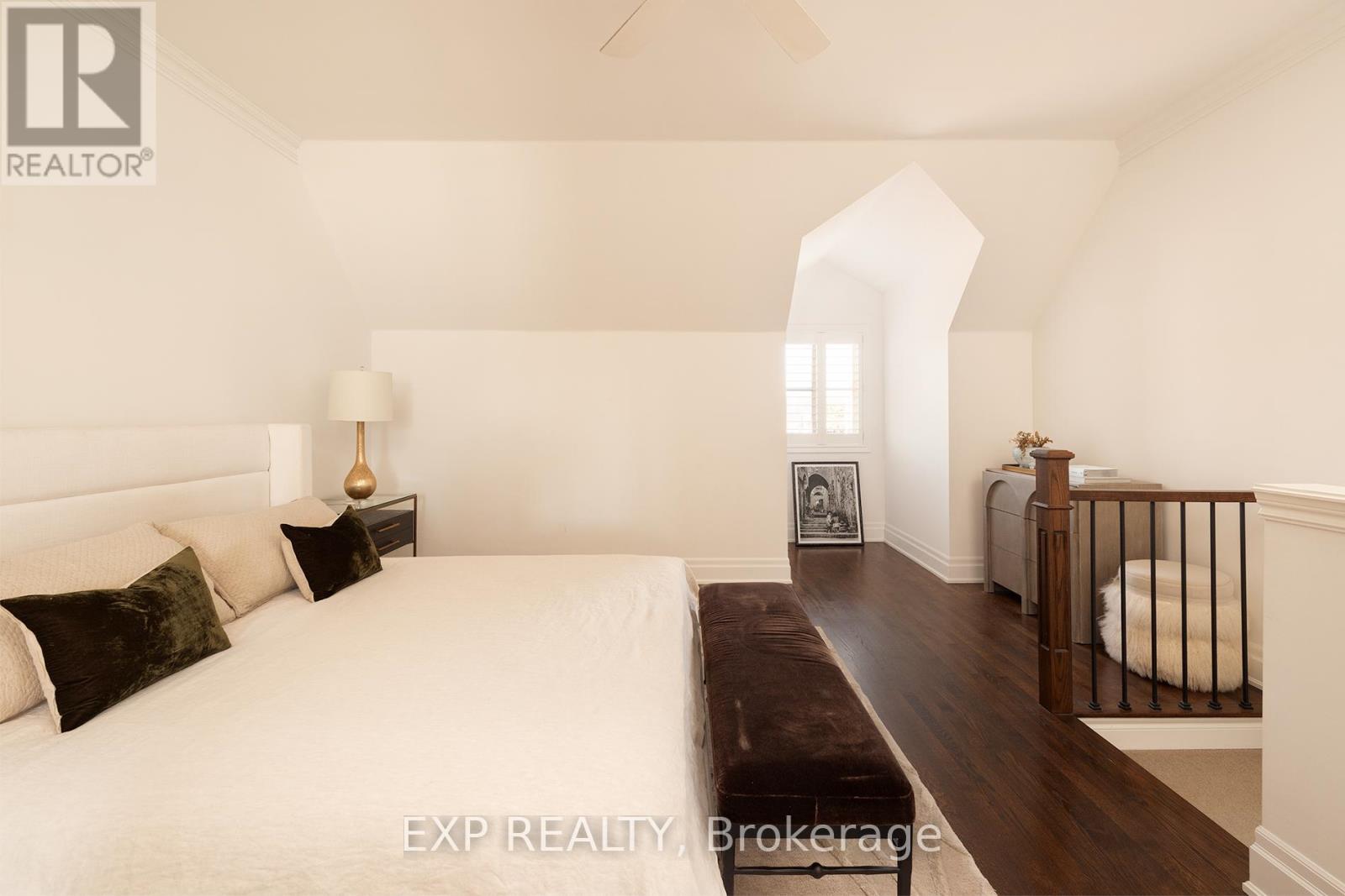 A bedroom with a large bed and a bench in the middle of the room.
