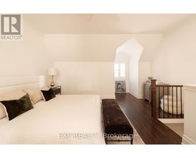 A bedroom with a large bed and a bench in the middle of the room.
