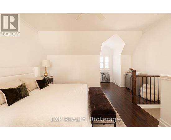 A bedroom with a large bed and a bench in the middle of the room.