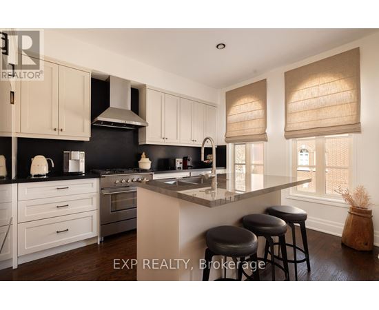 A kitchen with white cabinets and black countertops.