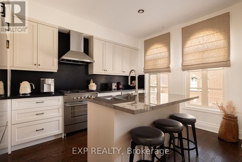 A kitchen with white cabinets and black countertops.
