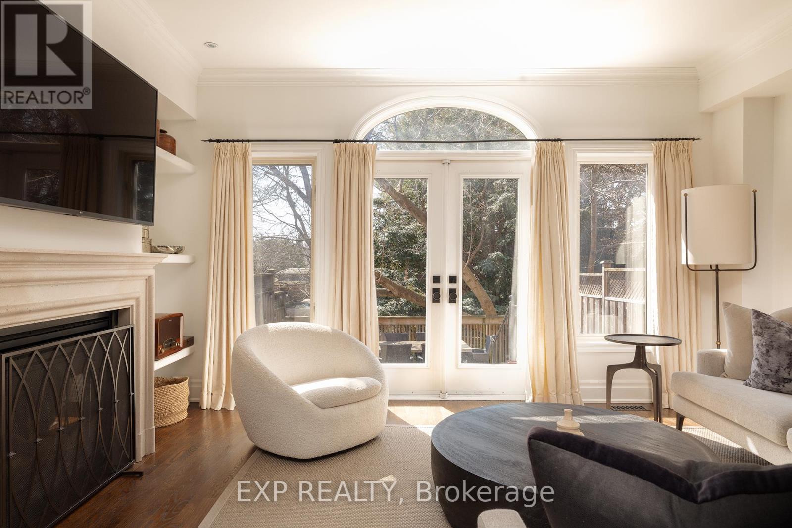 A modern living room with a fireplace and a large window with curtains.