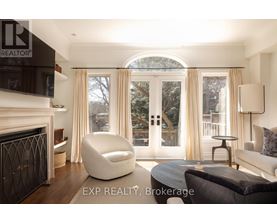 A modern living room with a fireplace and a large window with curtains.