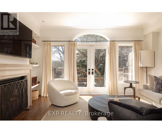 A modern living room with a fireplace and a large window with curtains.