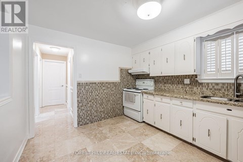 A kitchen with white cabinets and a tiled backsplash.