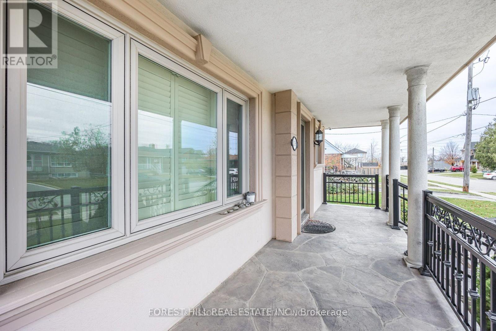 A balcony with a black railing and a stone floor.