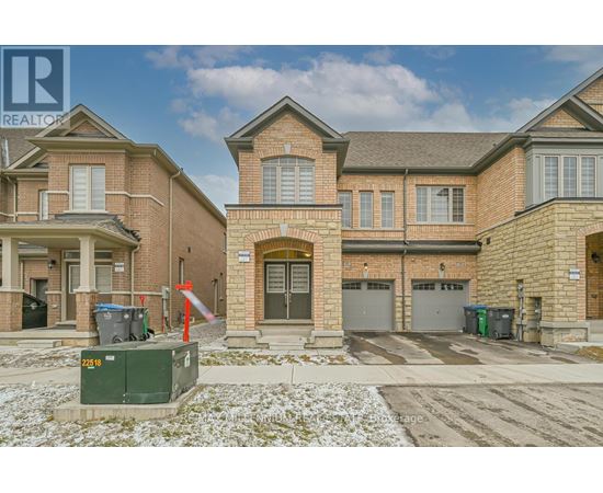A large brick house with a garage and a driveway in front.