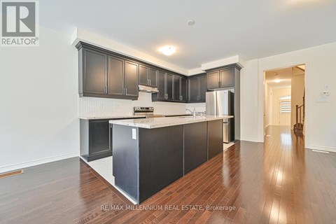 A kitchen with dark wood cabinets and a white island.