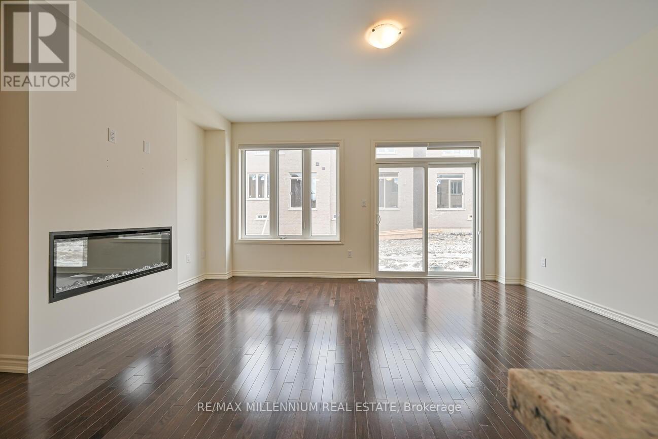 A spacious room with wooden floors and a large window.