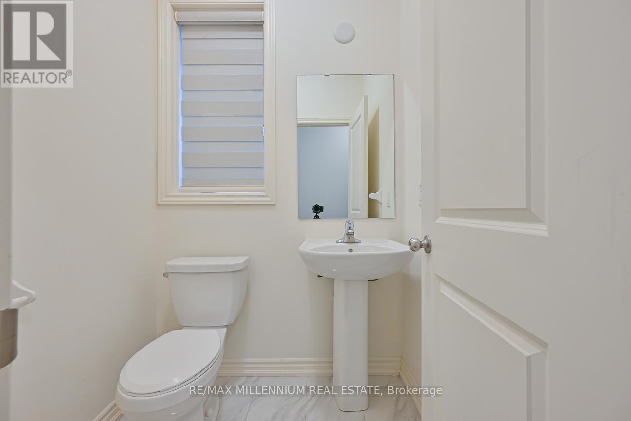 A white toilet and sink in a small bathroom.
