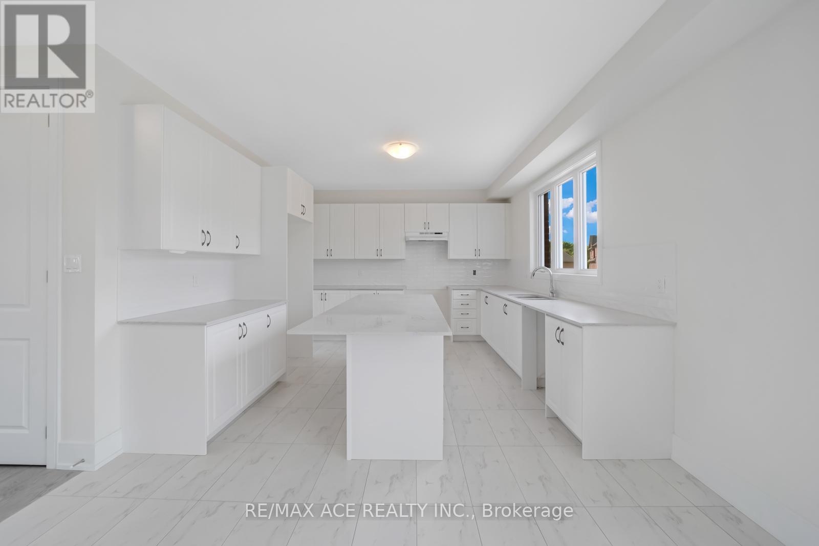 A white kitchen with a large island in the middle.