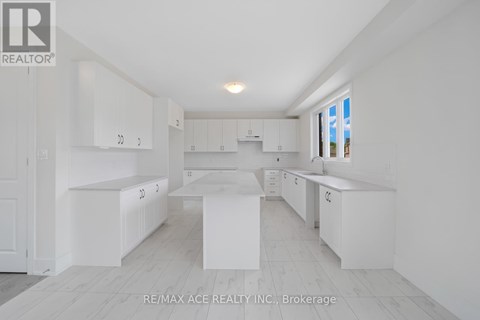 A white kitchen with a large island in the middle.