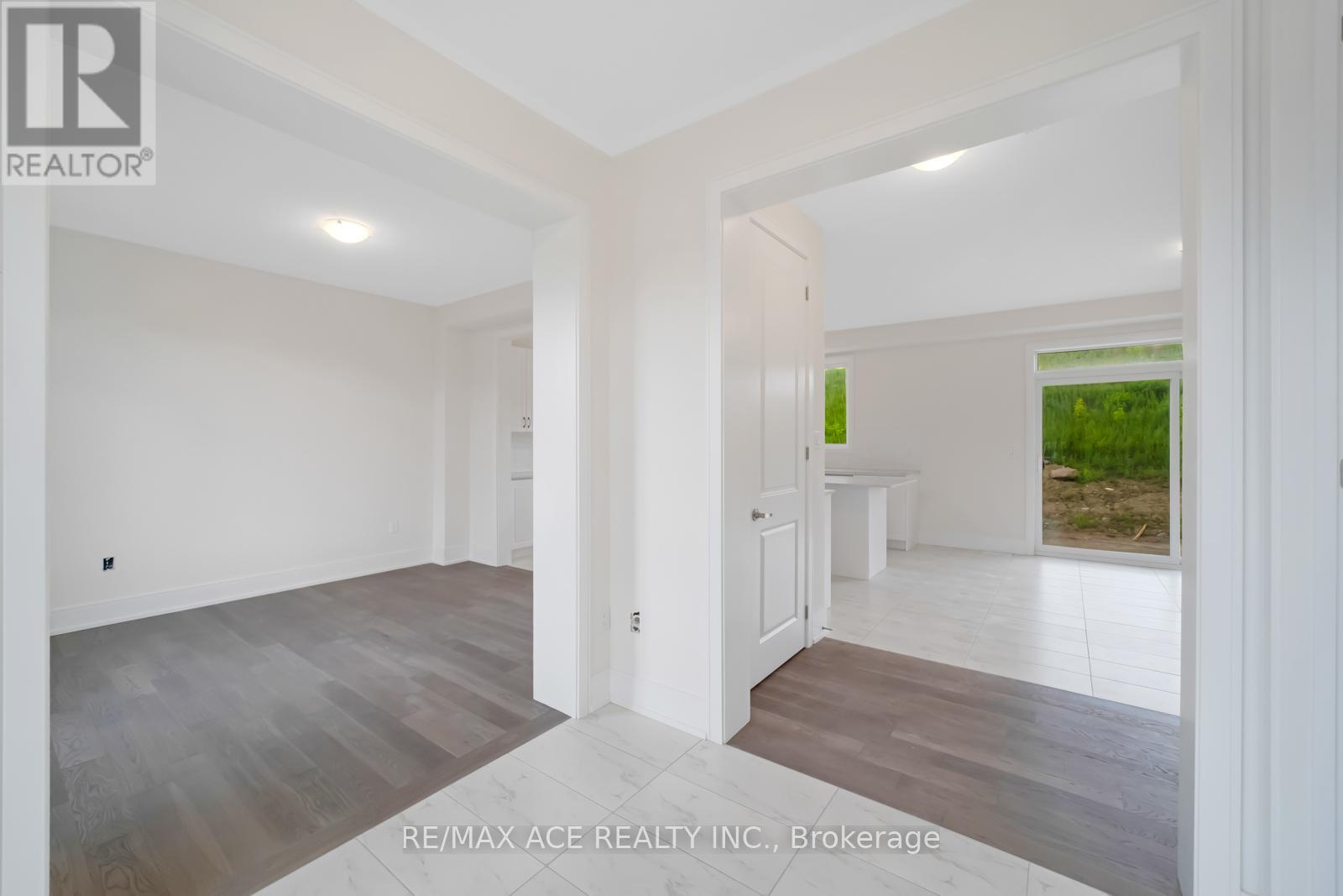 A spacious room with a white door and a window.