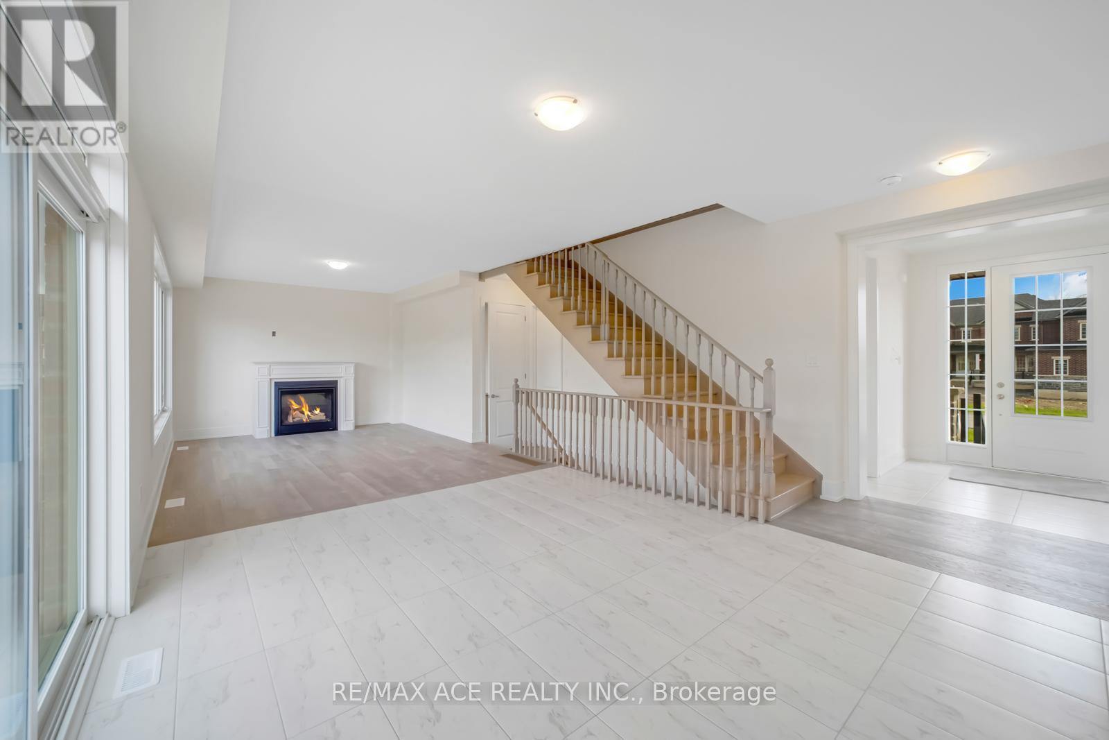 A spacious living room with a fireplace and a staircase.
