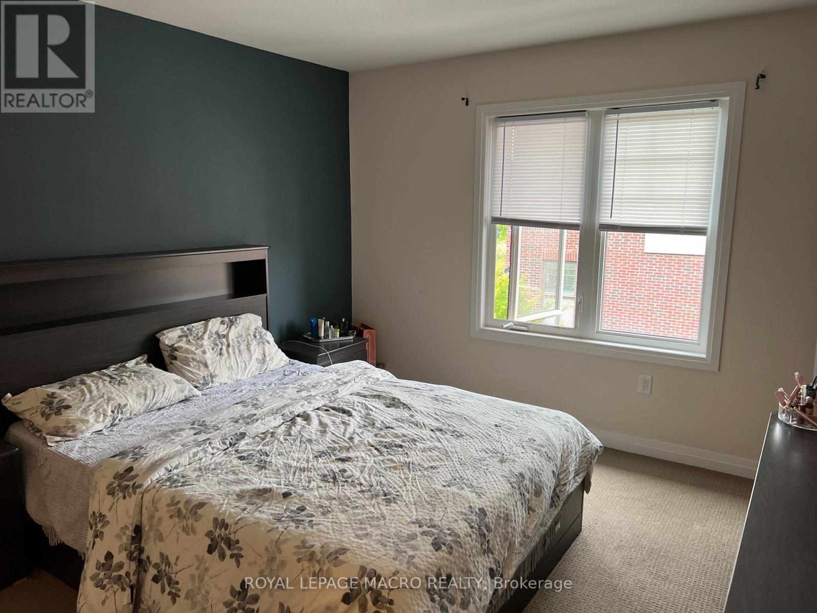 A bedroom with a bed, nightstand, and window.