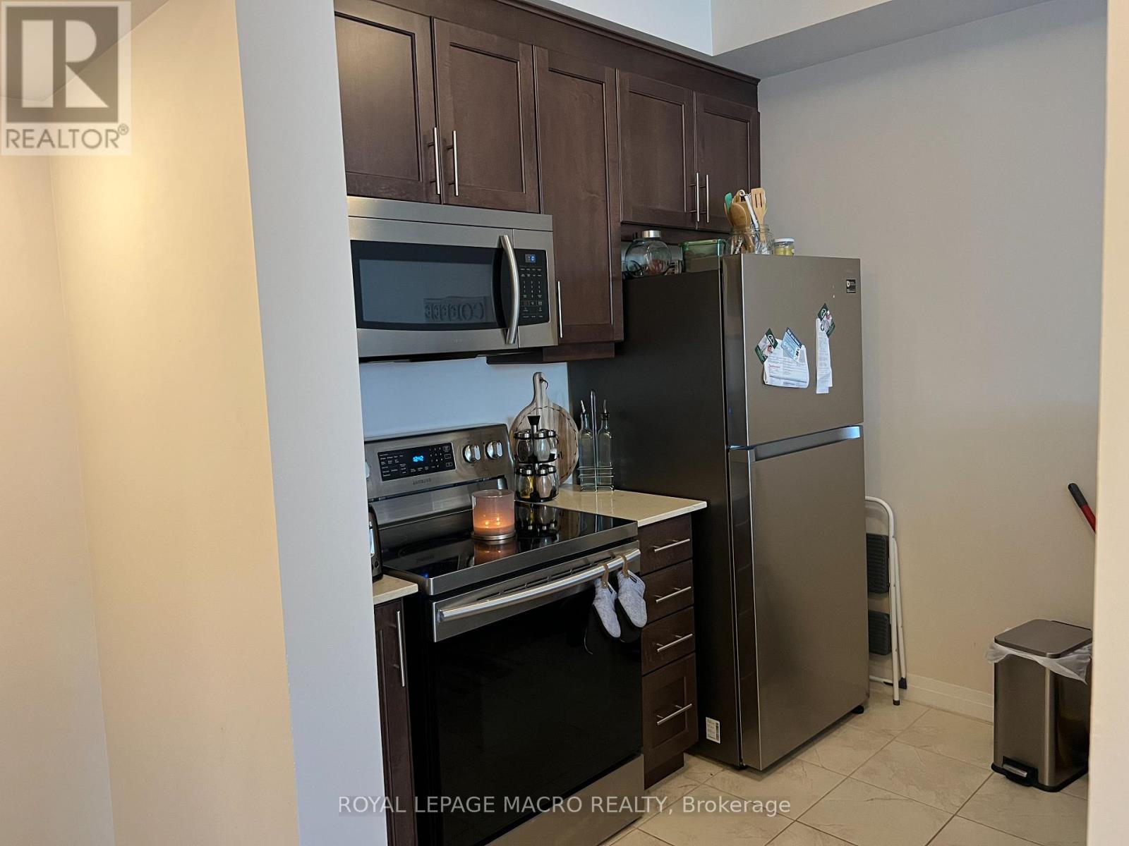 A kitchen with a stove, oven, microwave, and refrigerator.