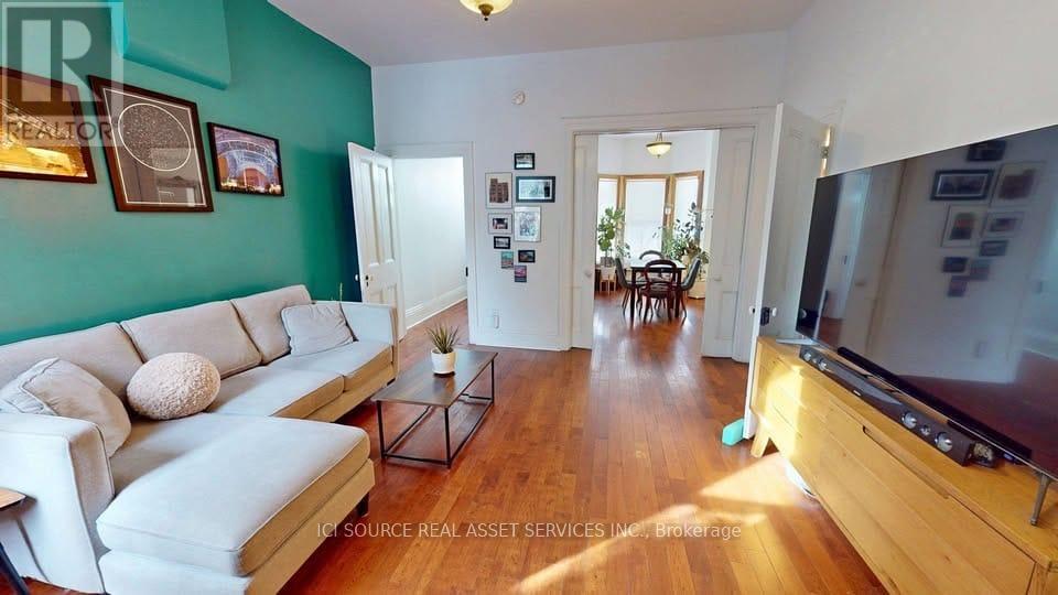 A living room with a white couch and a wooden floor.